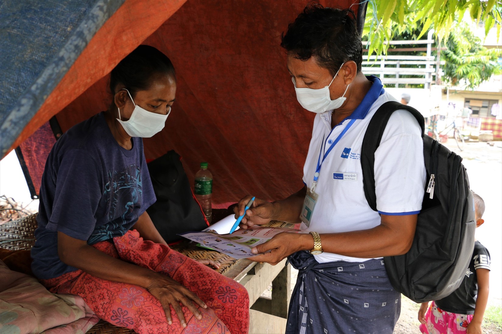 A volunteer is providing TB health education in slum area