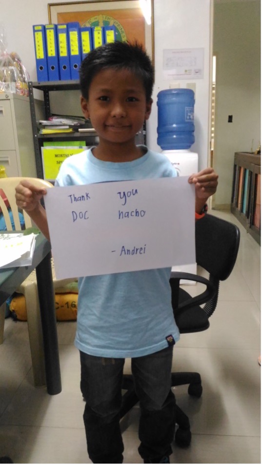 Andrei holding a thank you note for Dr. Monedero