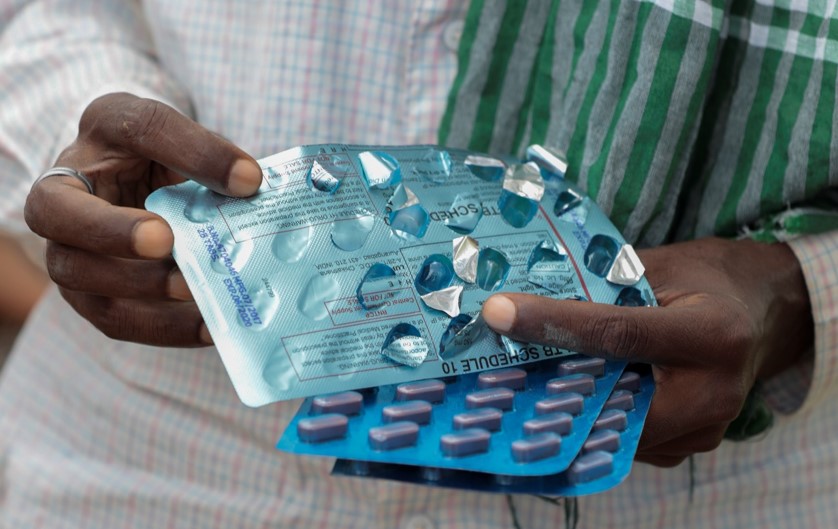 Man holding different types of TB medication