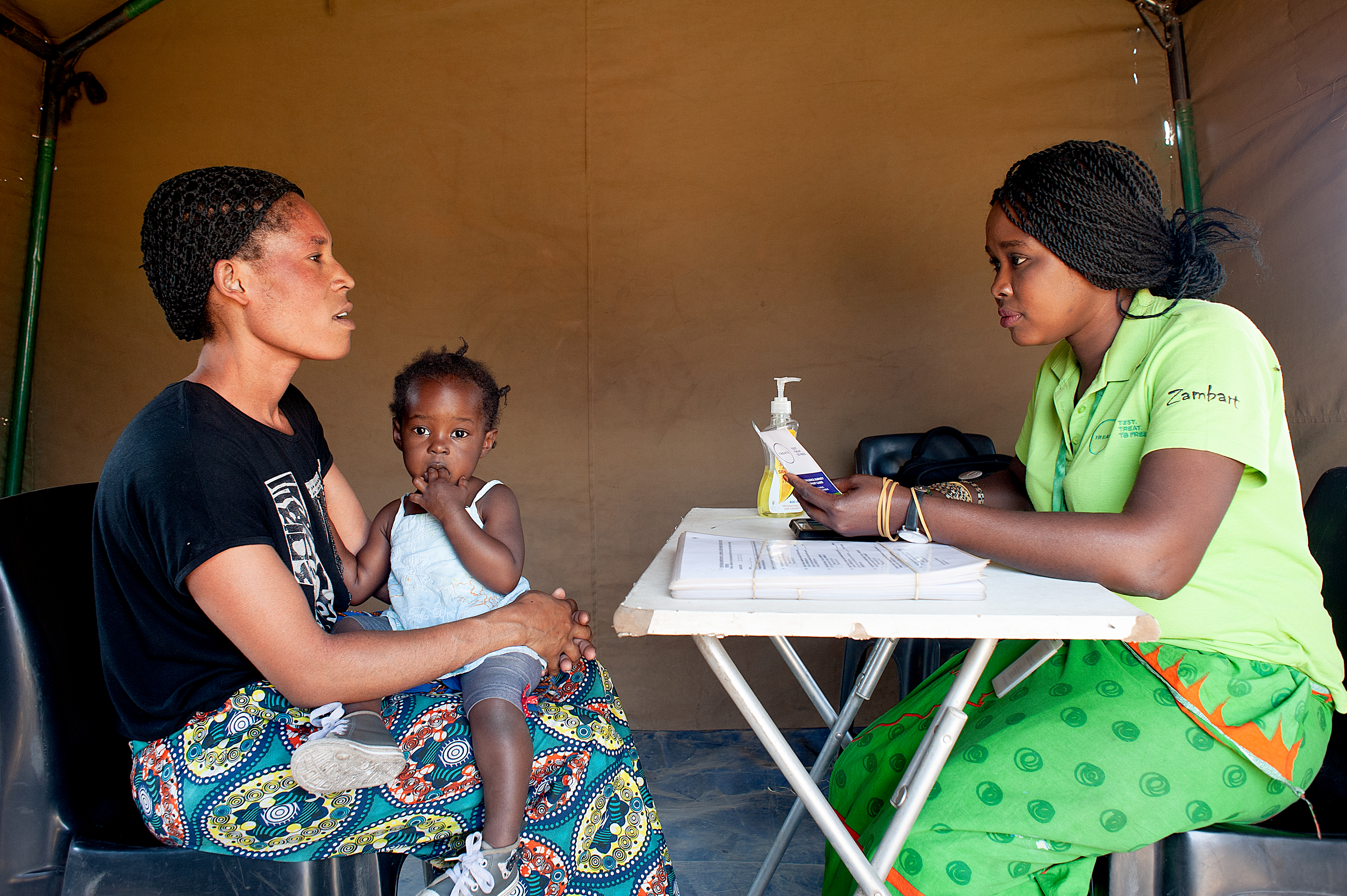 Mother and child sat with community healthcare worker