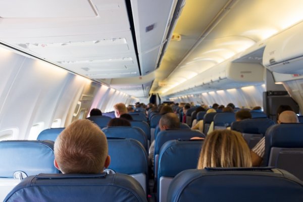 Shows passengers at a window seat on a plane